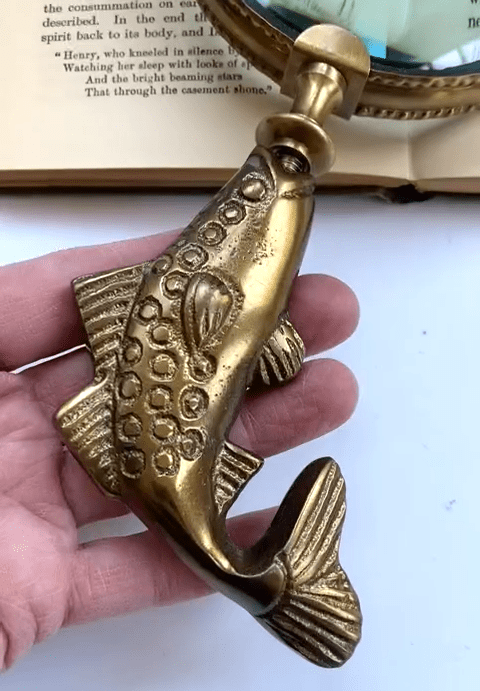 Handle detail of brass fish shaped magnifying glass