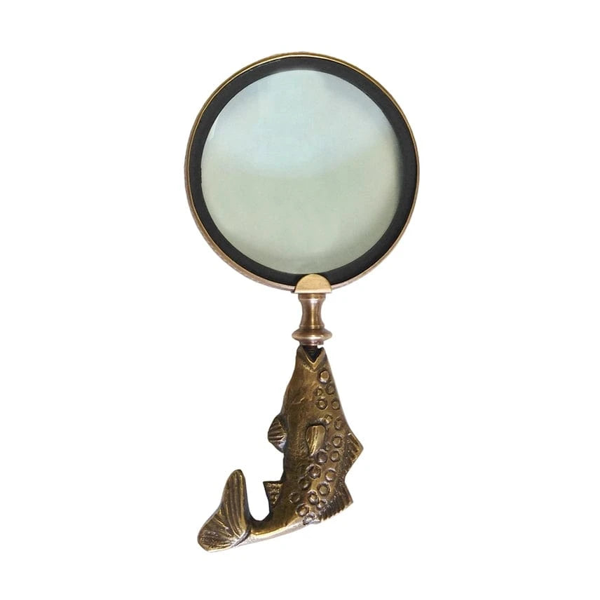 Brass magnifying glass with a fish-shaped handle on a white background