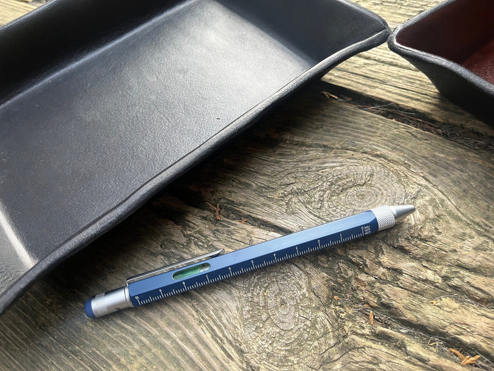 Troika blue pen shown next to leather trays