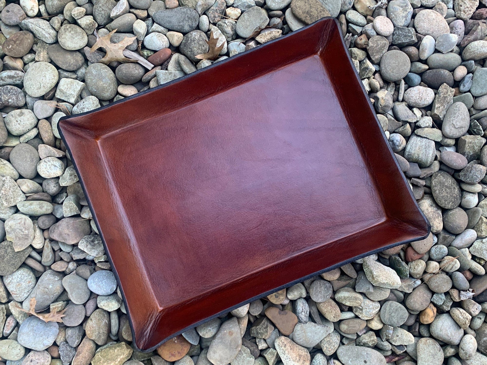 Dark brown paper-sized valet tray with black underside