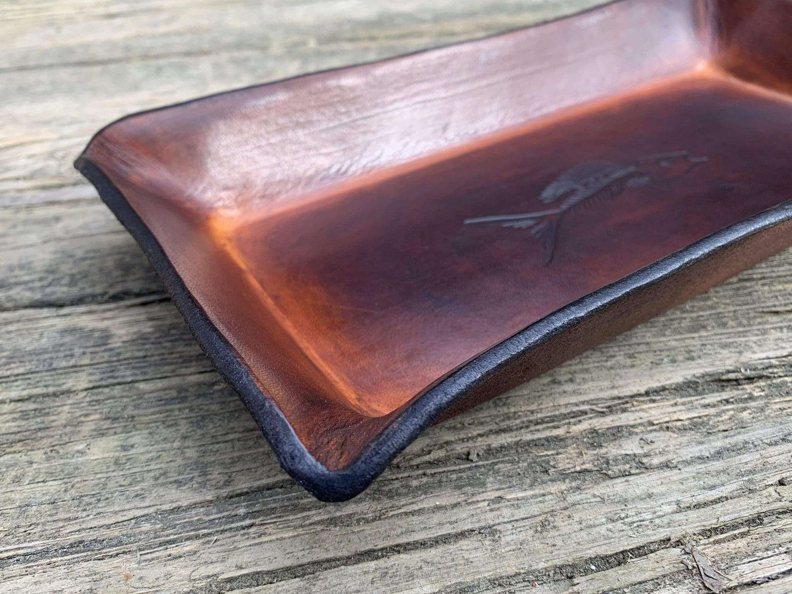 detail of embossed leather desk tray with fish fossil.