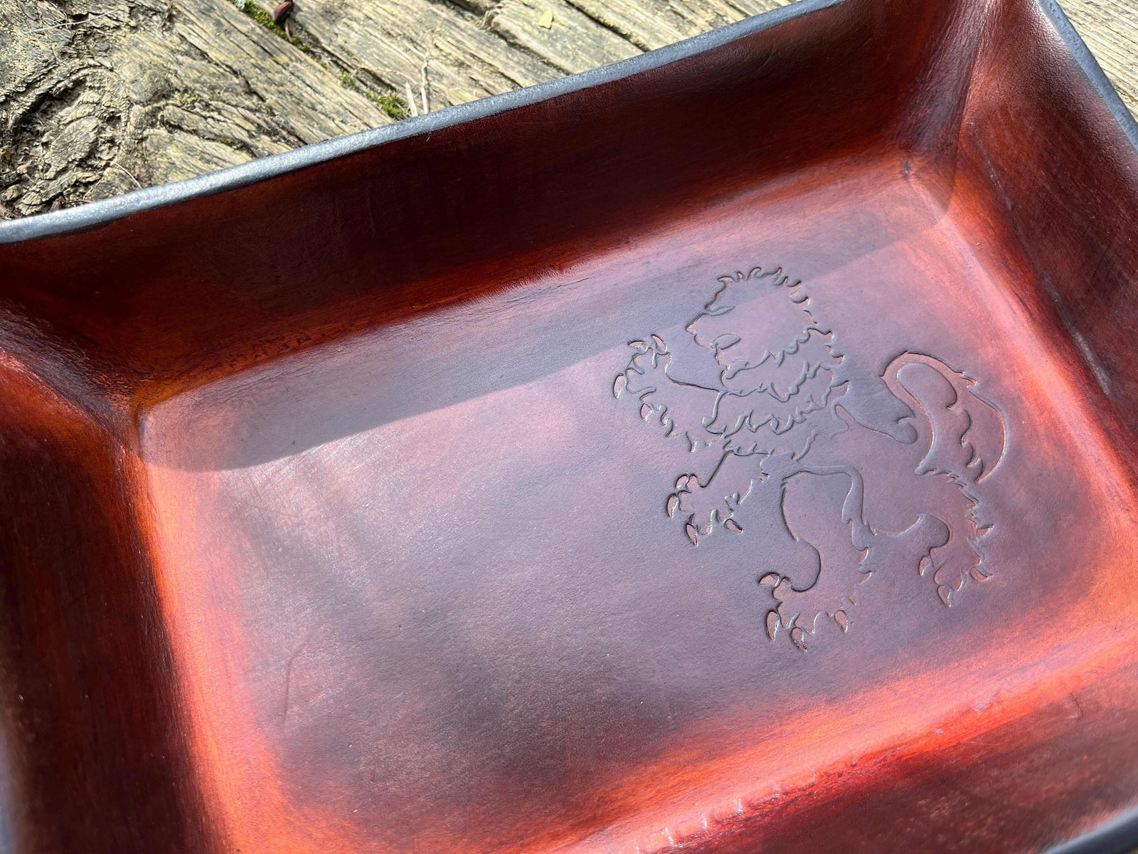 Detail of rampant lion leather valet tray in timber brown.