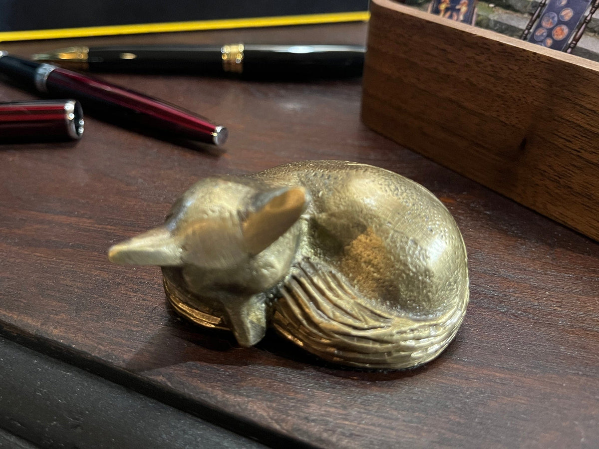 Small brass sleeping fox paperweight