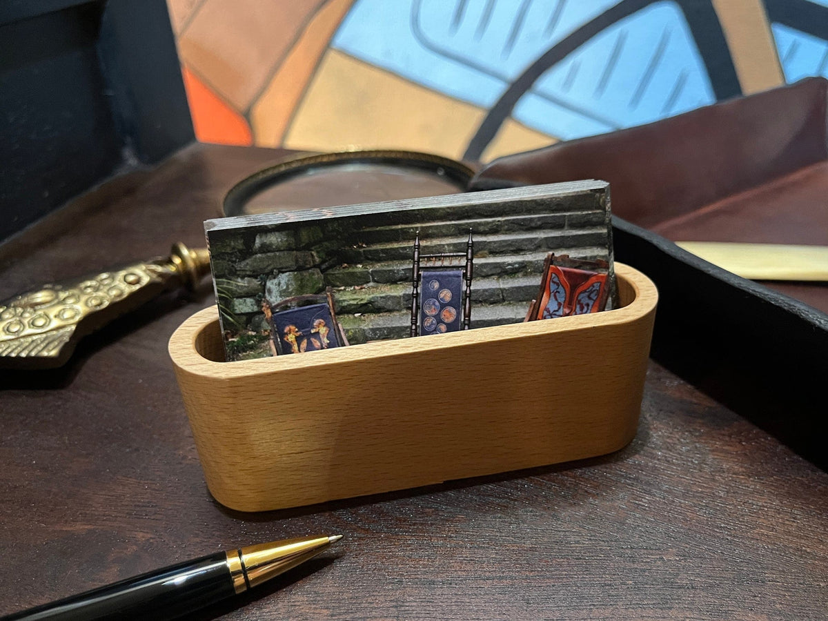Light colored wooden business card holder with business cards on a wooden surface