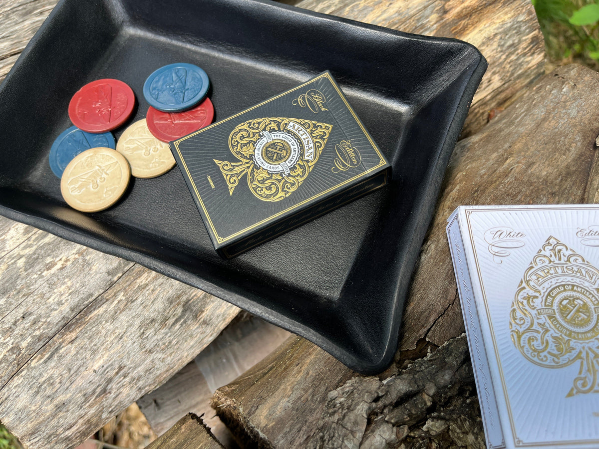 Artisan black playing cards shown inside a black leather tray with multicolored poker chips