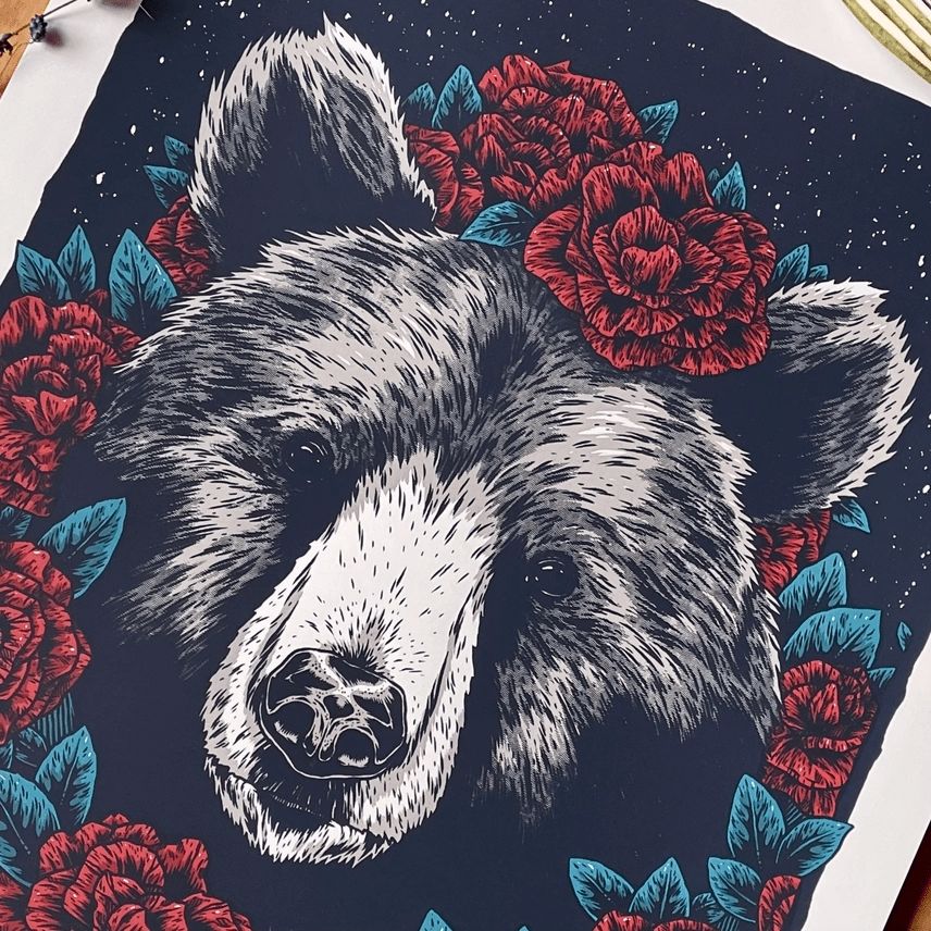 Detail of face of silkscreened print of a  black bear surrounded by roses