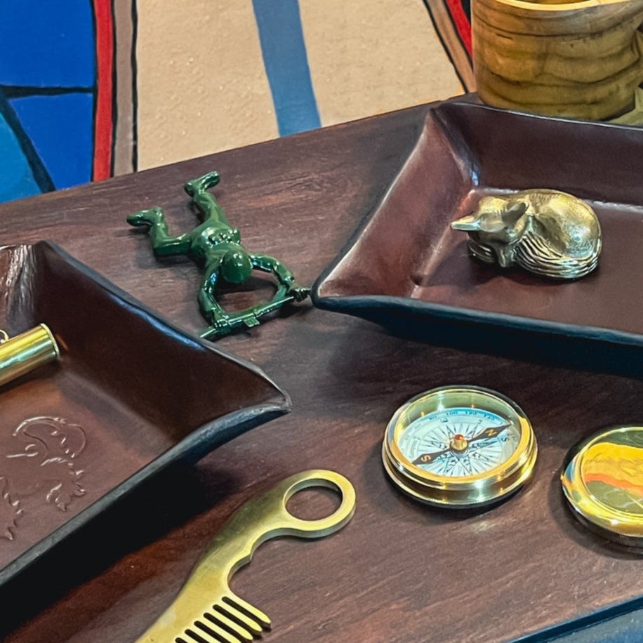 A collection of products for the modern adventurer shown on a desk with an colorful painting in the background