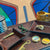 A collection of products for the modern adventurer shown on a desk with an colorful painting in the background