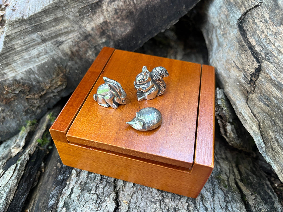 Set of three pewter woodland animals shown atop a wooden keepsake box