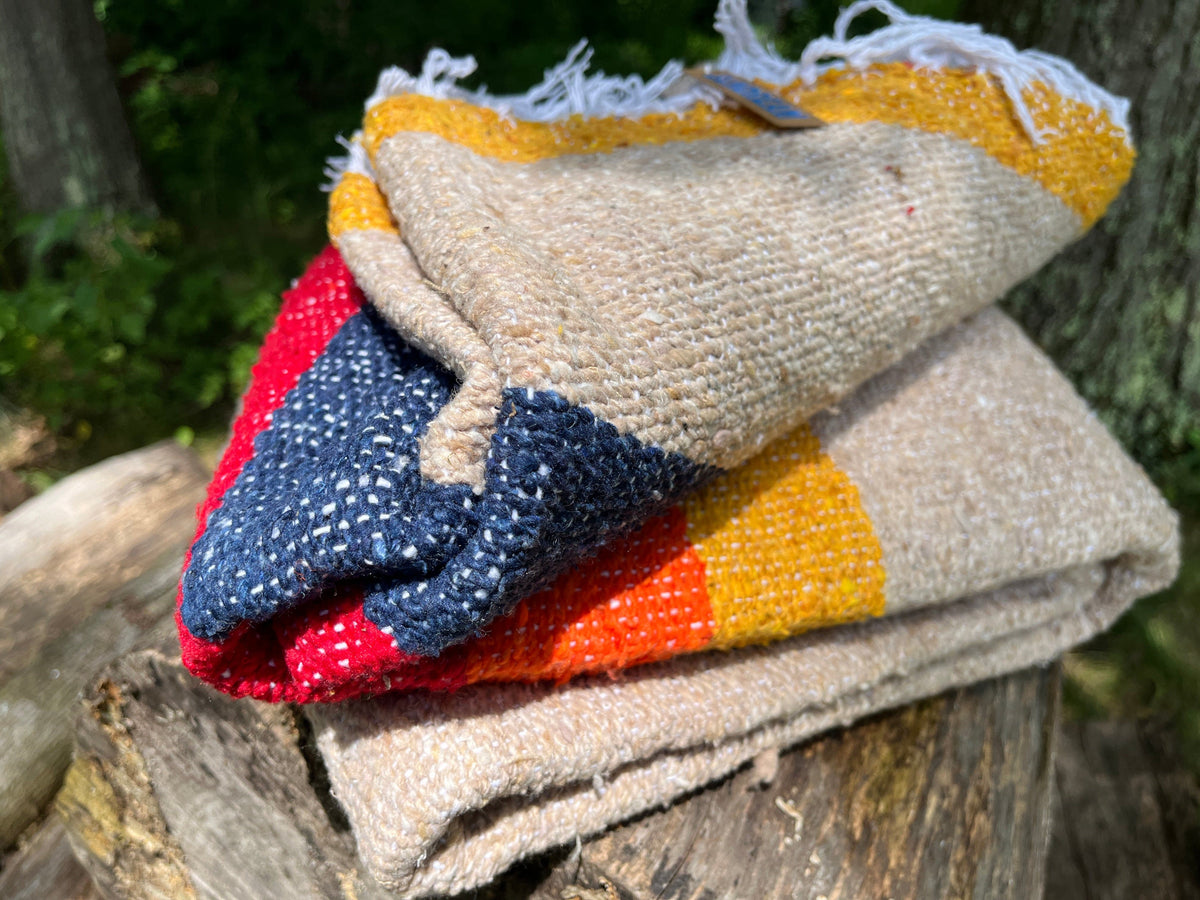 Vintage desert patterned recycled throw blanket. Shown partially unfolded.