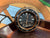 Seiko Mai dive style alarm clock in black and gold shown on desk