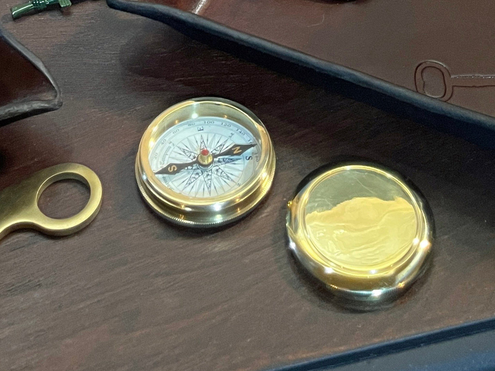 closeup of solid brass compass shown on a desk.