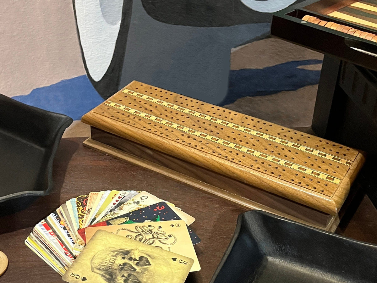 Walnut wood cribbage board shown with other games and accessories