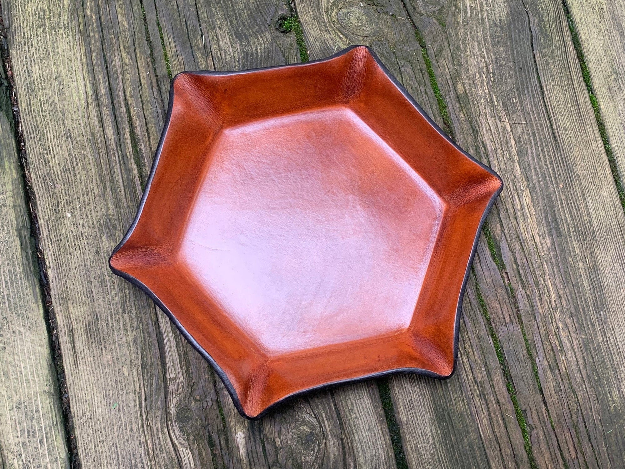Hexagonal tan leather tray on a wooden surface