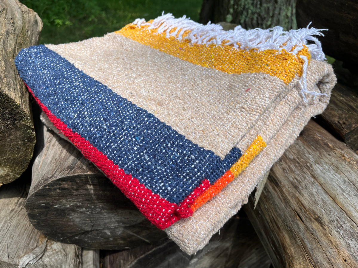 beige, blue, red, yellow and orange striped blanket. Folded