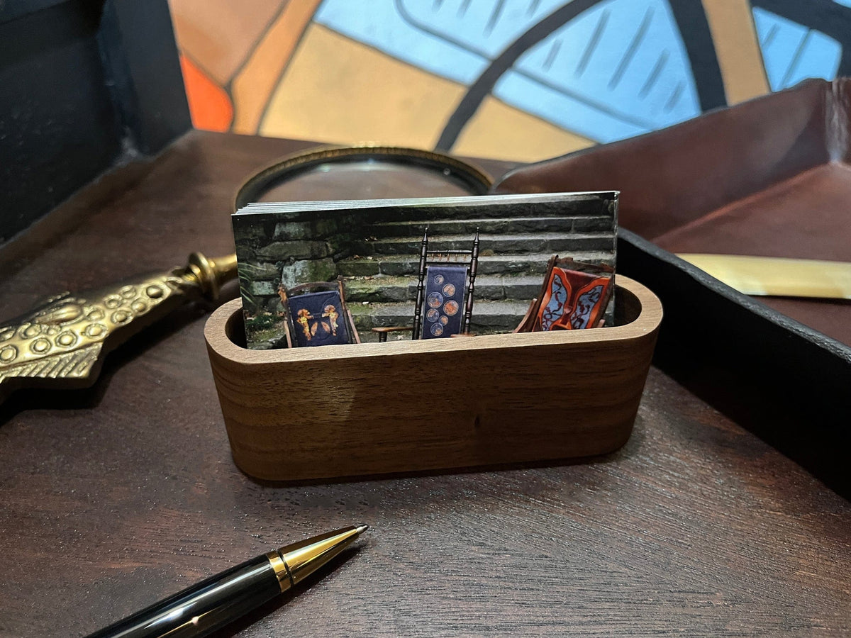 Walnut wood business card holder with cards on a desk surface