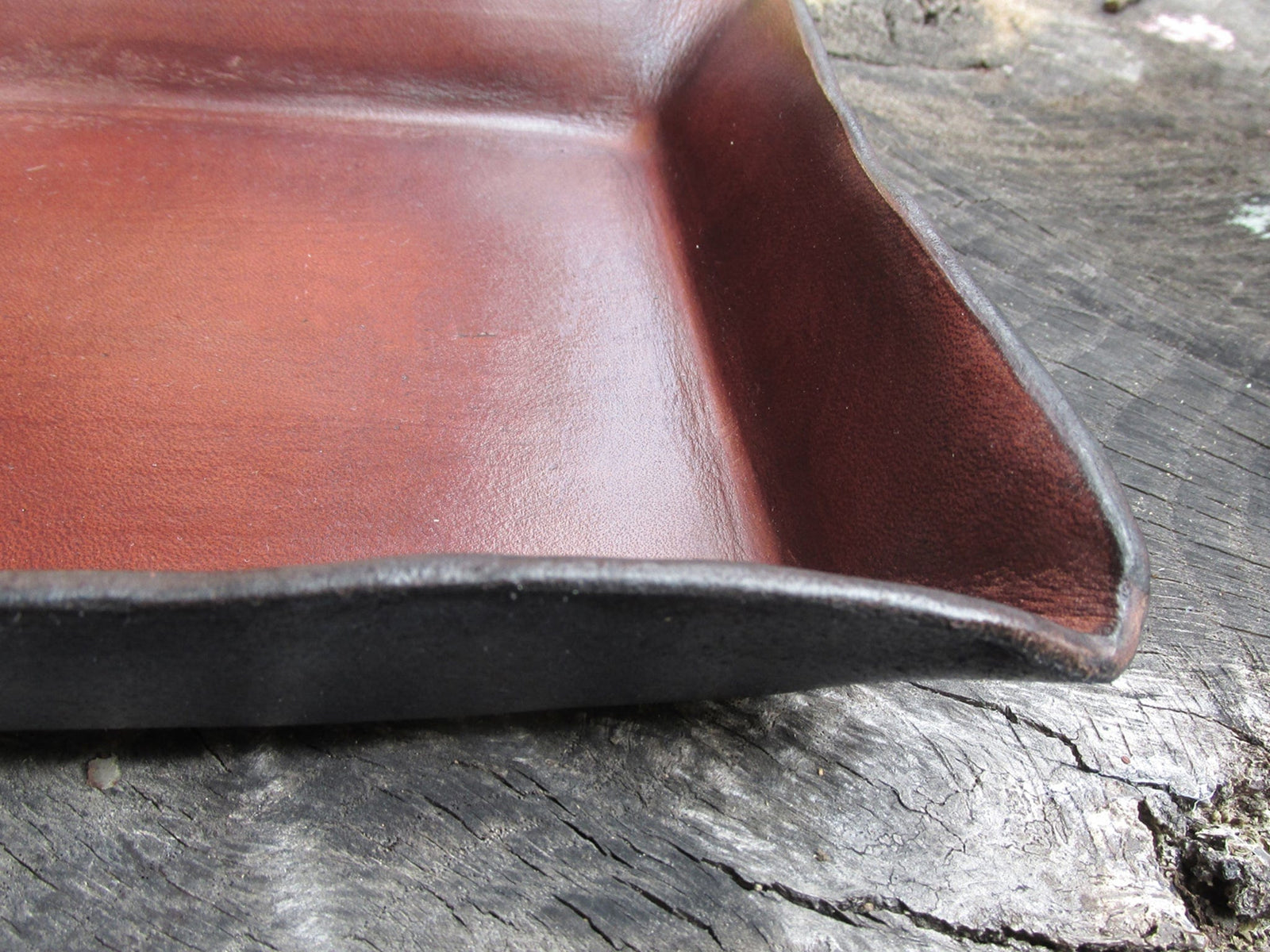 Corner detail of a brown leather valet tray