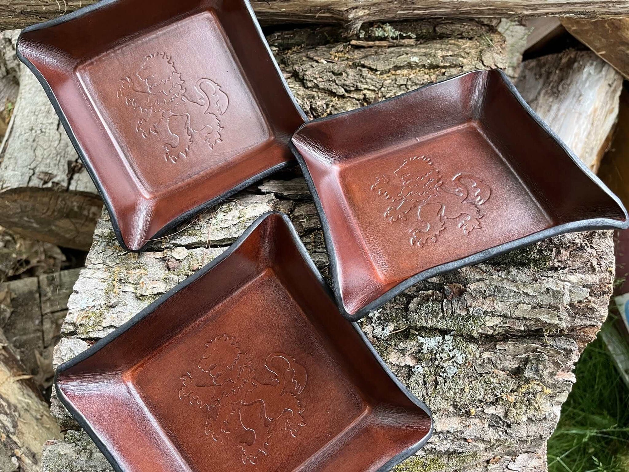 View of multiple square leather valet trays with heraldic lion image