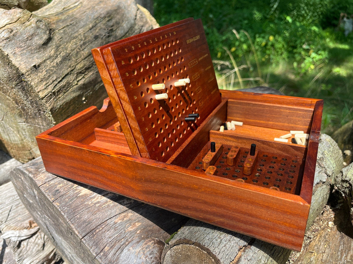 Wooden strategy game box with compartments on a natural wooden surface