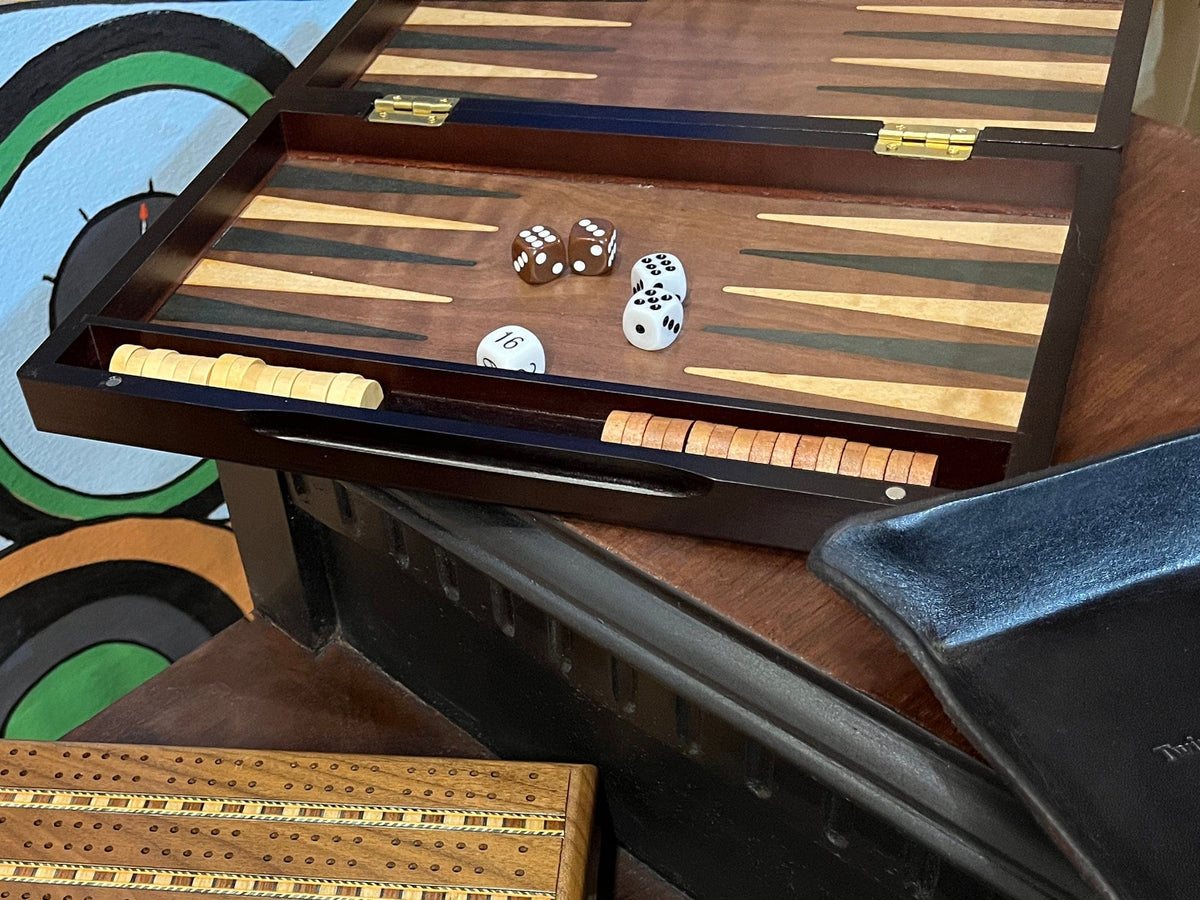 Wooden backgammon game set with walnut finish shown on desk with other items and games
