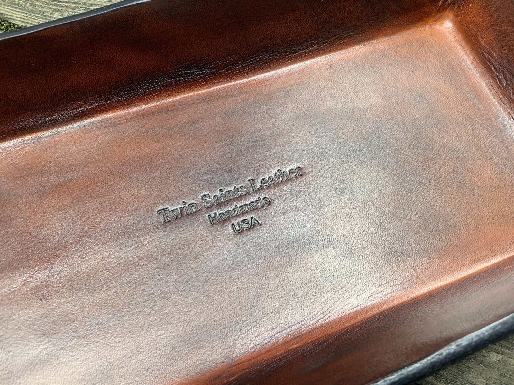 Detail of brown leather tray with logo