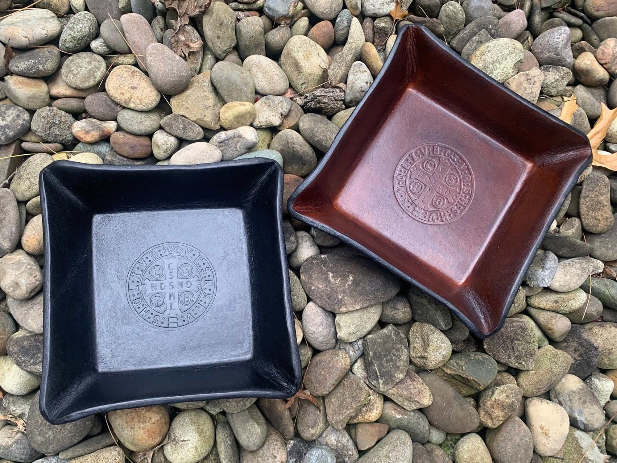 Brown and black valet trays with Saint Benedict medal images